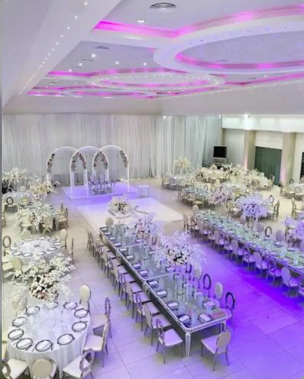 The Main Hall dressed with white flowers, a long table and circular chairs